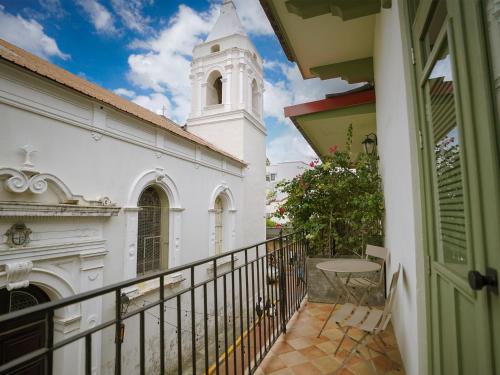 un balcon donnant sur le clocher d'une église et une tour d'horloge dans l'établissement Hotel Boutique Casa Marichu con Piscina, Rooftop y Balcón en Casco Viejo, à Panama City