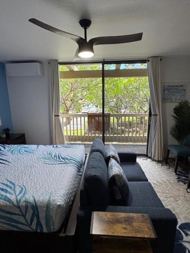 a living room with a couch and a ceiling fan at Stylish Studio Condo Near Magic Sands Beach in Kailua-Kona