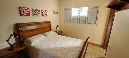 a small bedroom with a bed and a window at Recanto do Nenei in Paraisópolis