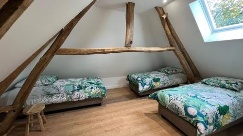 a bedroom with two beds and a window at Domaine de la Vacquerie in Alette