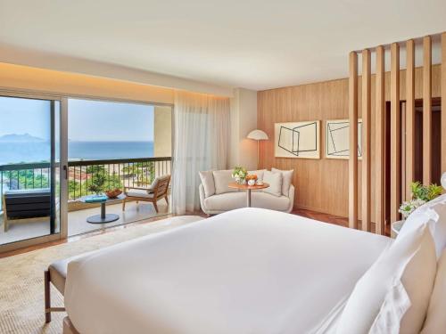 a bedroom with a large bed and a living room at Fairmont Rio de Janeiro Copacabana in Rio de Janeiro