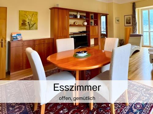 a kitchen and dining room with a wooden table and chairs at Salzkammergut Homes Gmunden - Lake View Apartment, Blick auf den Traunsee und auf das Schloss Orth - ideal für Paare und Genießer in Gmunden