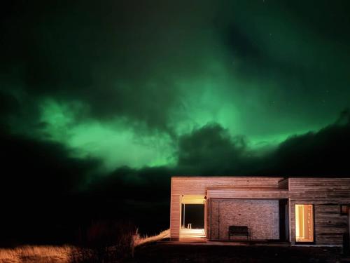 a building with the northern lights in the sky at Nordic House Lofoten in Ramberg