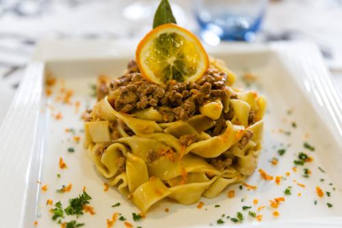 a plate of pasta with a lemon on top at Maison Cly in Chamois