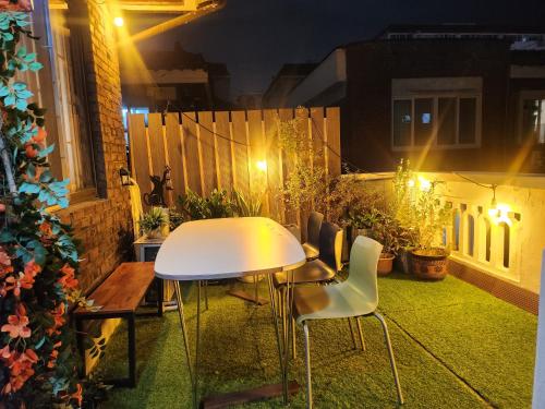 un tavolo bianco e sedie su un balcone di notte di Urban a Suwon