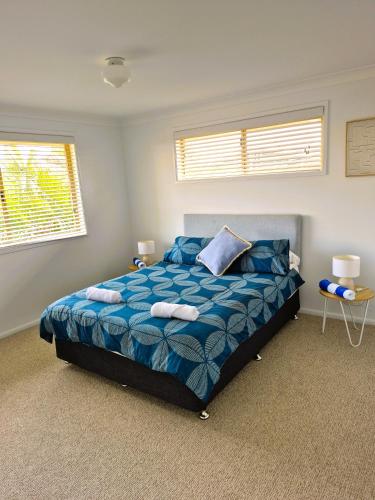 a bedroom with a bed with two towels on it at Beachfront Bliss in Lennox Head