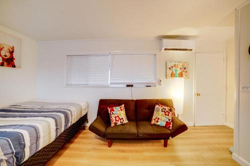 1 dormitorio con 1 cama y 1 silla con almohadas en Work and Play! Studio 7 Mi to Dtwn San Bernardino, en Rialto