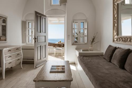 a living room with a couch and a table at Aqua Luxury Suites by NOMÉE Hospitality Group in Imerovigli
