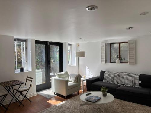 a living room with a couch and a chair at Bright Garden Suite Across From Park in Kitsilano in Vancouver