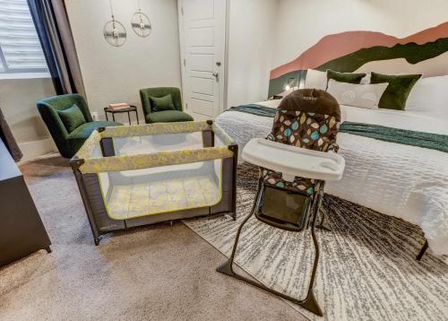 a bedroom with a bed with a chair and a chair at Institute Den Downtown Modern Basement Suite in Colorado Springs