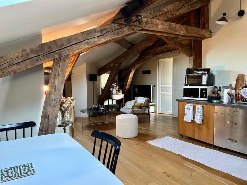 een keuken en een woonkamer met houten balken bij Nid douillet sous les toits bourguignons in Dijon