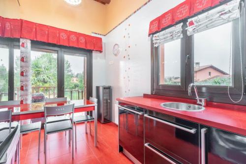 La Campachalet en san justo的厨房配有红色台面和窗户。