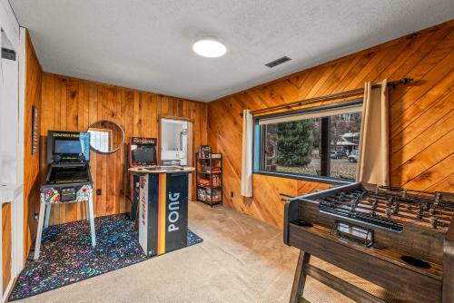 une pièce avec des murs lambrissés de bois et une salle de jeux dans l'établissement Leif's Adventure Haus - Hot Tub - Downtown - Pet Friendly, à Steamboat Springs