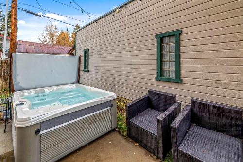 un jacuzzi avec deux chaises longues à côté d'un bâtiment dans l'établissement Leif's Adventure Haus - Hot Tub - Downtown - Pet Friendly, à Steamboat Springs