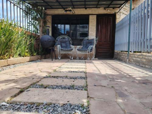 2 sillas de mimbre sentadas en un patio en Hospedaje SKYHOME II, en Nu Guazu