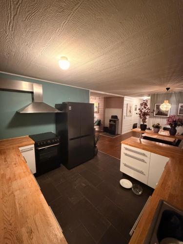 a kitchen with a black refrigerator and a counter at Recently renovated house in the heart of tromsdalen in Tromsø