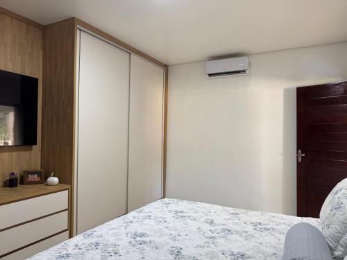 een slaapkamer met een bed, een dressoir en een kast bij Refúgio na natureza in Parauapebas