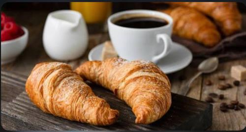 a table topped with croissants and a cup of coffee at Ice Apartments Luxury Ocean View in Reykjavík
