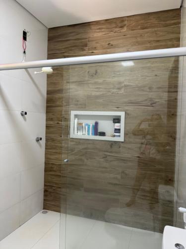 een badkamer met een douche en een houten muur bij Refúgio na natureza in Parauapebas