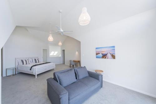 Unit 8 8- 10 Electra Parade Harrington في Manning Point: غرفة معيشة مع أريكة وسرير