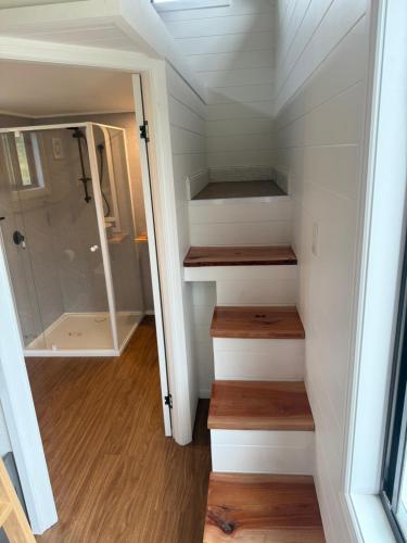 a tiny house with stairs leading to a bedroom at Ferncroft Farm Tiny Home Berry in Wattamolla