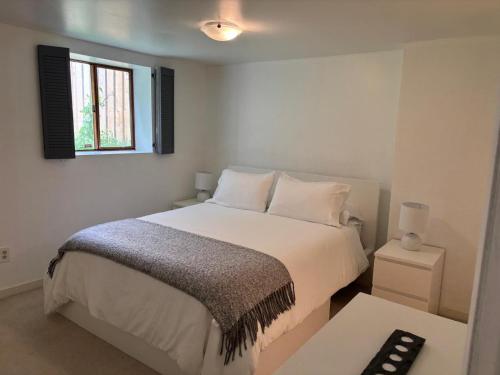 een witte slaapkamer met een bed en een raam bij Bright Garden Suite Across From Park in Kitsilano in Vancouver