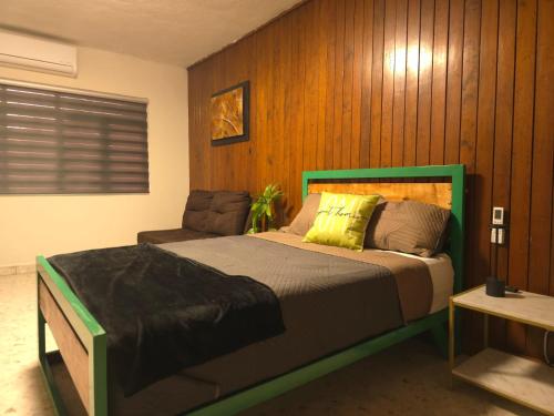 una camera da letto con un letto e una sedia di Renta de habitación desde 1 noche baño privado a Saltillo