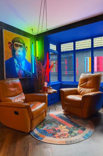 a living room with two leather chairs and a painting at The Funky Hideaway with hot tub in Bangor