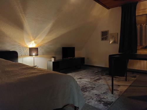 a bedroom with a bed and a table and a lamp at Apartmentzimmer KEINE MONTEURE in Rheine