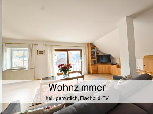 ein Wohnzimmer mit Sofa und Tisch in der Unterkunft Salzkammergut Homes Gmunden - See- und Stadtblick, zentrale Lage, Balkon - ideal für Familien in Gmunden