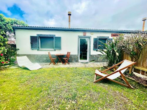 une maison avec deux chaises et une table dans la cour dans l'établissement Sea Roots "Garden Zone ", à Mosteiros