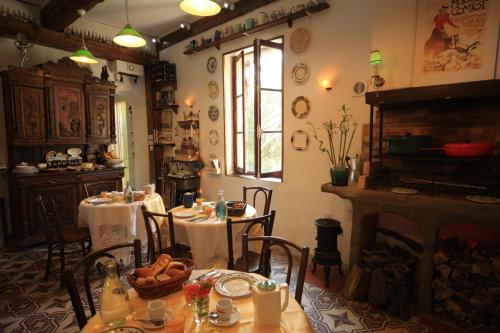 a dining room with two tables and a fireplace at Maison De L'Orb in Béziers