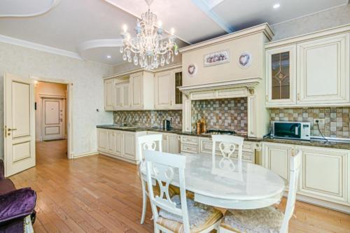 a kitchen with a table and chairs and a chandelier at Mc Donalds Hotel Apartment Nizami Street in Baku