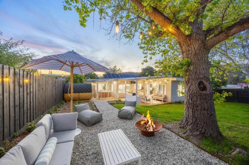 un cortile con buca per il fuoco e un albero di The Meadow Yarra Valley Large Entertainer with Spa & Sauna a Yarra Glen
