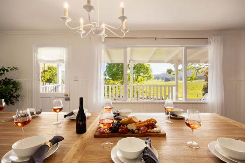 una sala da pranzo con tavolo e bicchieri di vino di The Meadow Yarra Valley Large Entertainer with Spa & Sauna a Yarra Glen