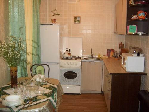ヴォルゴグラードにあるApartments on Parhomenko st.のキッチン(コンロ、冷蔵庫、テーブル付)
