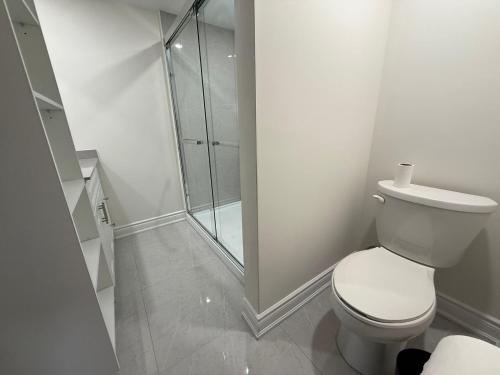 a bathroom with a toilet and a glass shower at Howard Johnson by Wyndham Brampton in Brampton