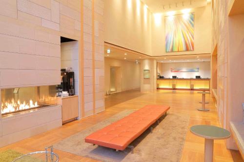a lobby with a bench and a fireplace at Hotel Resol Trinity Sapporo in Sapporo