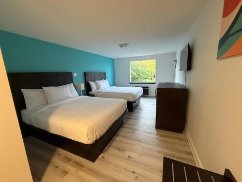 a hotel room with two beds and a window at Howard Johnson by Wyndham Brampton in Brampton