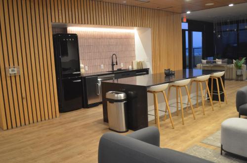 a kitchen with a counter and a bar with stools at 2bd 2bth Highrise in the heart of Roosevelt District! in Phoenix