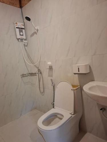a bathroom with a shower and a toilet and a sink at Fadel Bungalow ฟาดิลบังกะโล in Ban Lo Pa Ret