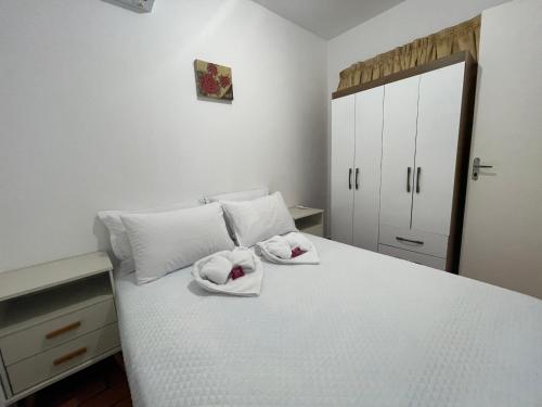 a bedroom with a white bed with towels on it at Casa com PISCINA no CENTRO - Estacionamento PRIVATIVO - 650m do Shopping JL in Foz do Iguaçu