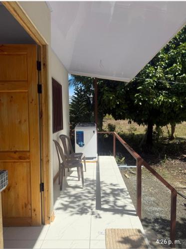 a porch with a chair and a refrigerator at Casita colibri in Savegre