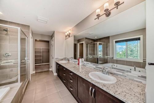 艾尔德里Waterfront Home, Fireplace, 90 min to Banff的大型浴室设有2个水槽和淋浴。