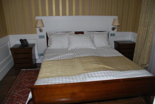 a bedroom with a large bed with a white headboard at Erzsébet Nagy Szálloda in Paks