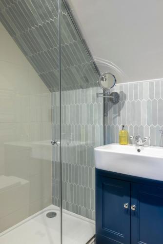 a bathroom with a sink and a glass shower at The Horns Pub - Crazies Hill in Hurley