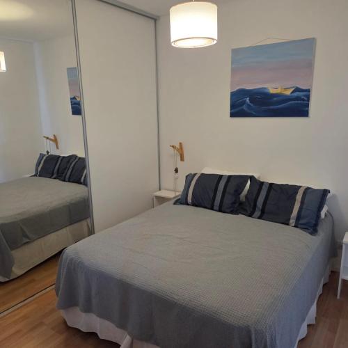a bedroom with a bed in front of a mirror at Miro del Mar in Puerto Pirámides
