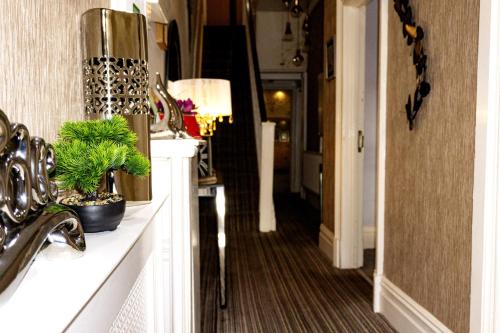 a hallway of a house with a sink and a mirror at Kenley Hotel in Blackpool