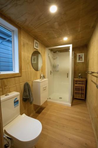 a small bathroom with a toilet and a shower at Mataura River Hideaway in Ardlussa