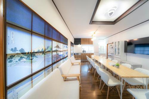 a dining room with white tables and white chairs at 家族旅館四国周遊元山 in Takamatsu